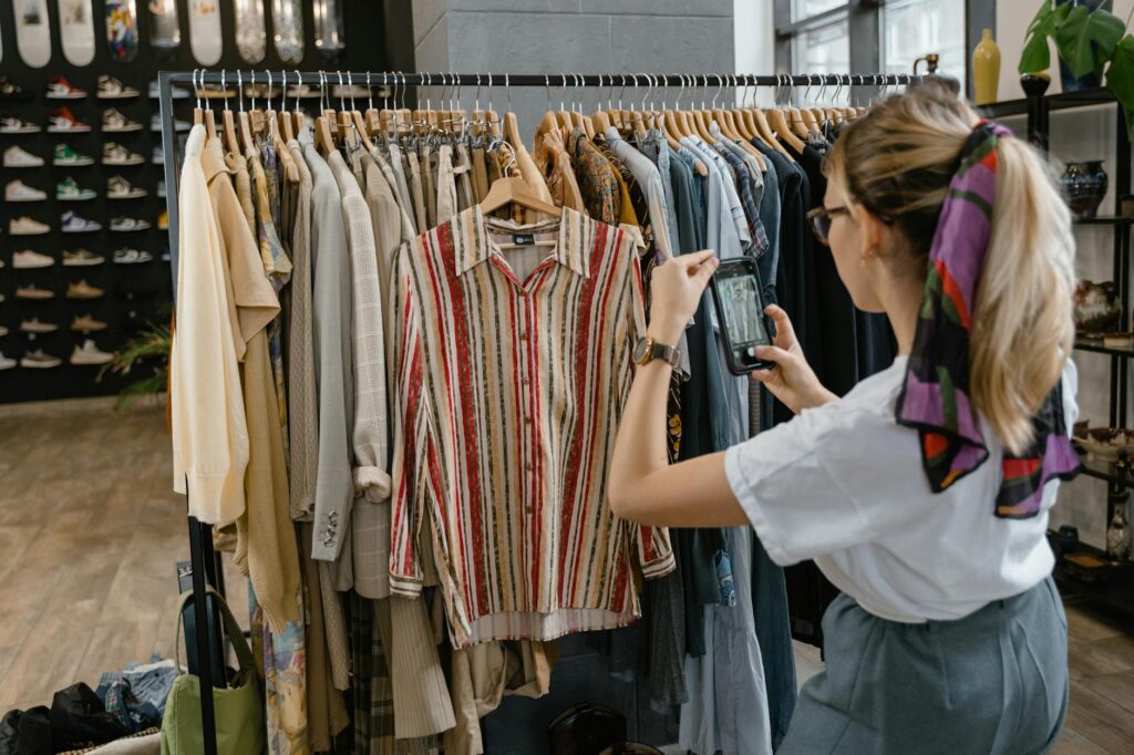 woman in white shirt taking photos of the clothes on the clothesline