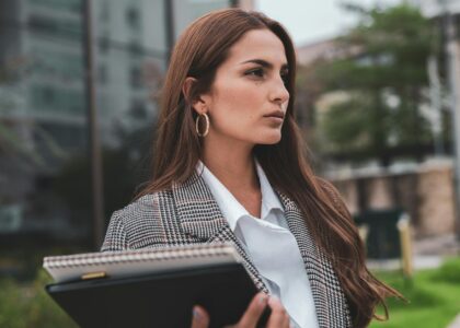 confident businesswoman standing outside building