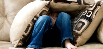 kid hiding on pillows