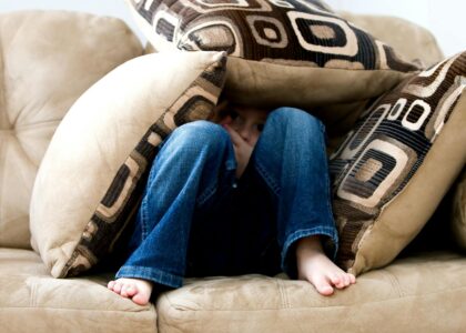 kid hiding on pillows