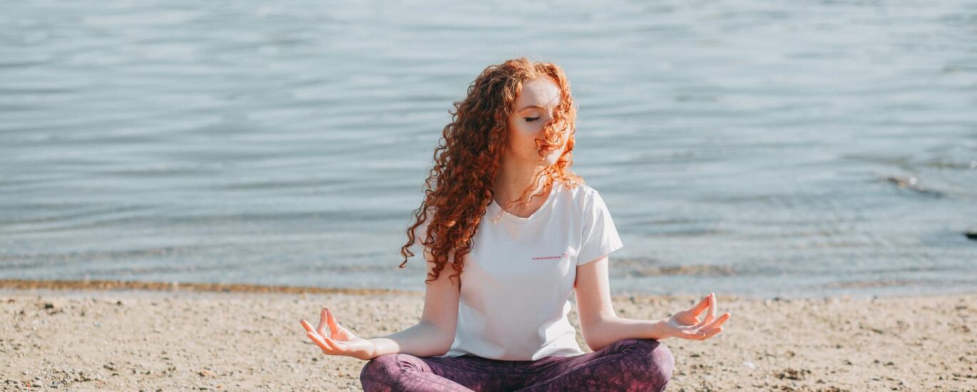 woman doing yoga exercise at the sea shore