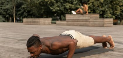 strong man practicing yoga in park