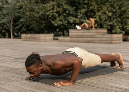 strong man practicing yoga in park